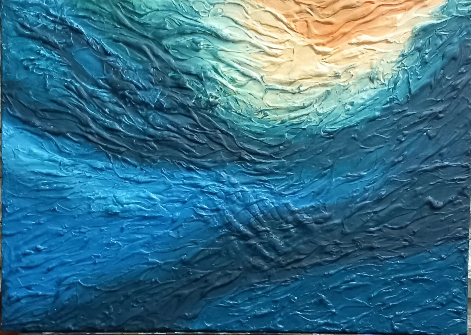 Textured blue waves under a gold sunrise